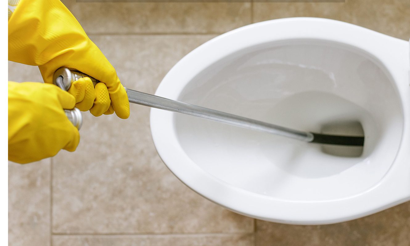 yellow gloves with toilet snake in toilet bowl